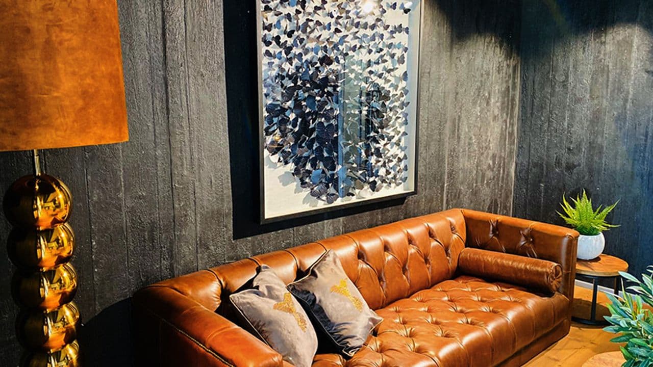 REal Stone Ledersofa vor schwarzer Wand